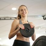 cheerful female athlete with circular weight